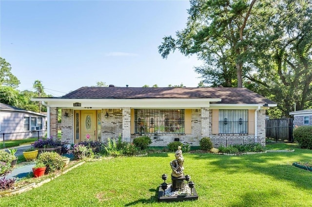 single story home featuring a front lawn, fence, and brick siding