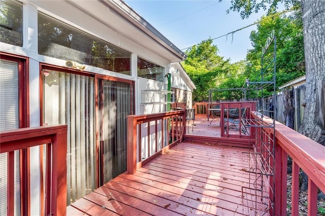 wooden terrace with outdoor dining area and fence