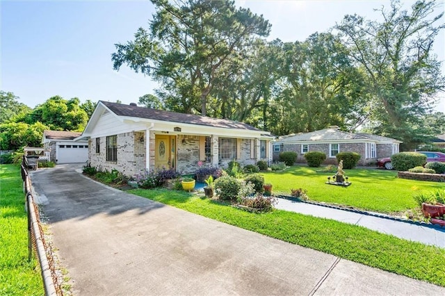 single story home featuring brick siding, a front lawn, an outbuilding, and a garage