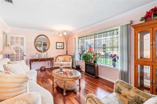 living room featuring visible vents, crown molding, baseboards, a textured ceiling, and wood-type flooring