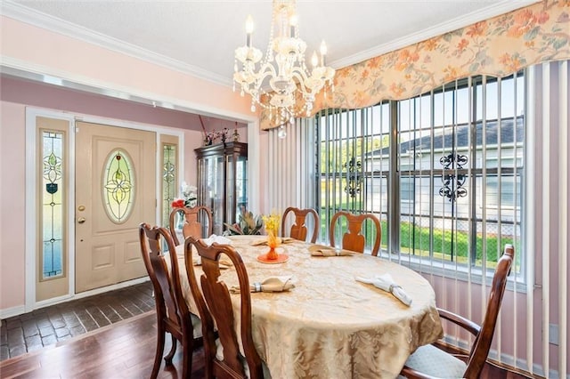 dining area with a chandelier, dark wood-type flooring, and ornamental molding