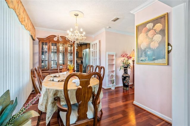 dining space featuring visible vents, a notable chandelier, dark wood finished floors, crown molding, and baseboards