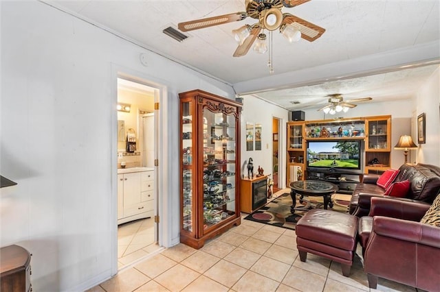 living room featuring light tile patterned floors, visible vents, and ceiling fan