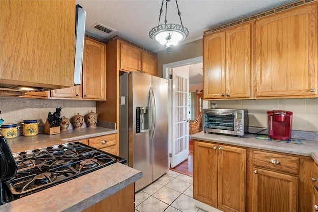 kitchen with visible vents, stainless steel refrigerator with ice dispenser, a toaster, light countertops, and light tile patterned floors