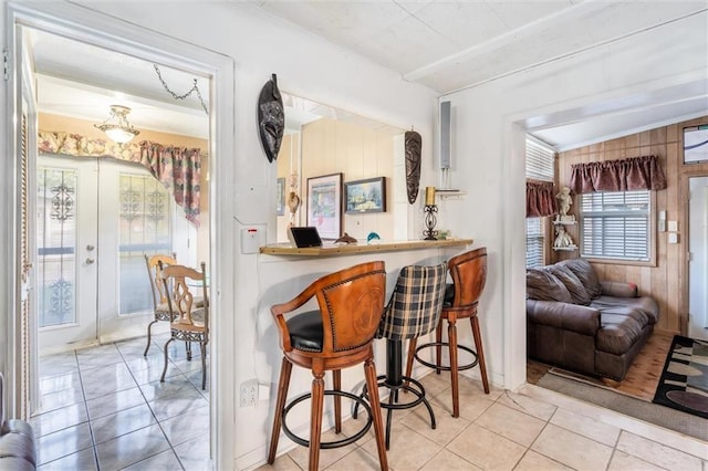 bar with tile patterned floors, a dry bar, and french doors