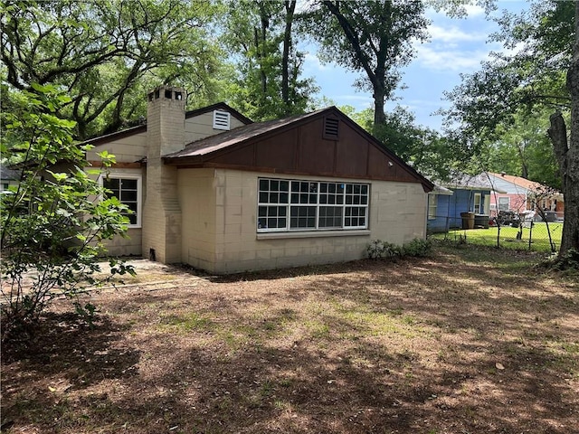3052 Jane St, Mobile, AL 36606 - view of home's exterior featuring fence, concrete block siding, and a chimney