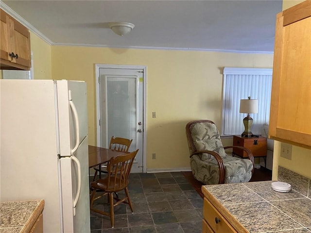 kitchen with white refrigerator and ornamental molding