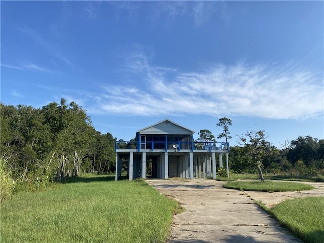 coastal home featuring a carport and a front lawn