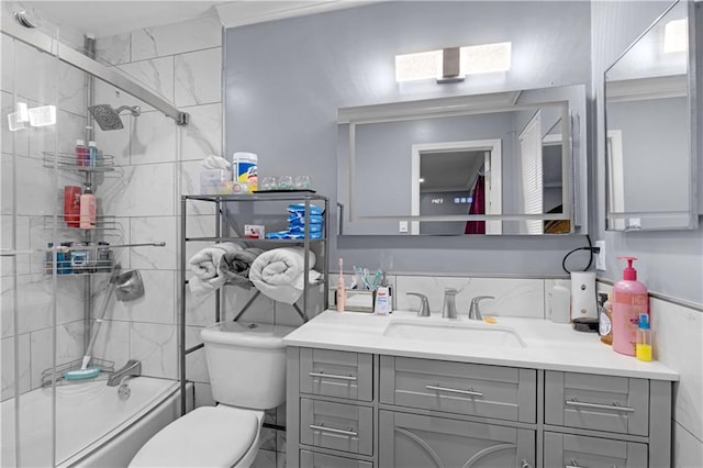 full bath featuring tile walls, vanity, toilet, and bathing tub / shower combination