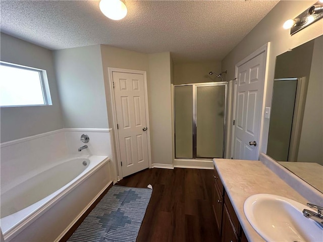 bathroom featuring vanity, hardwood / wood-style floors, shower with separate bathtub, and a textured ceiling