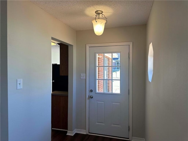 entryway featuring dark wood-type flooring and a textured ceiling