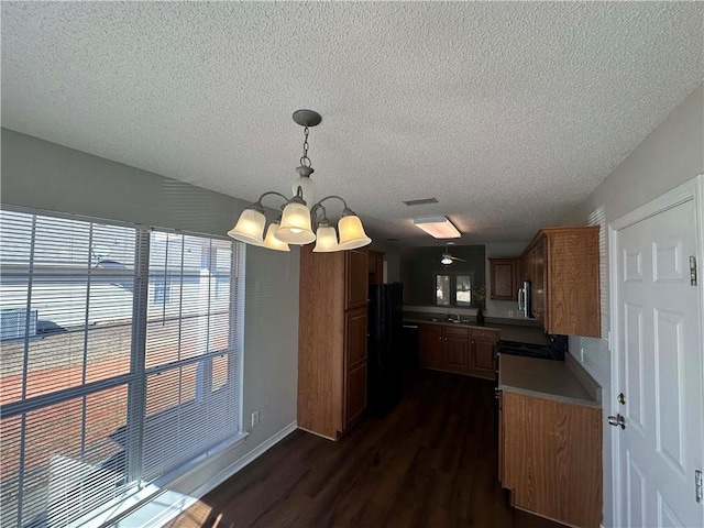 kitchen with sink, black refrigerator, hanging light fixtures, an inviting chandelier, and dark hardwood / wood-style flooring