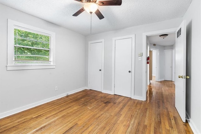 1101 Elmira St, Mobile, AL 36604 - unfurnished bedroom featuring wood-type flooring, a textured ceiling, baseboards, and ceiling fan