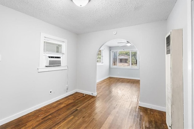1101 Elmira St, Mobile, AL 36604 - unfurnished room featuring a heating unit, arched walkways, wood finished floors, a textured ceiling, and baseboards