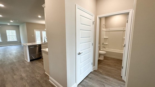 corridor with dark hardwood / wood-style flooring and sink