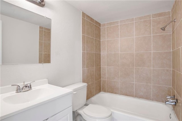 full bathroom with vanity, tiled shower / bath combo, and toilet