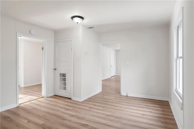 spare room with a healthy amount of sunlight and light hardwood / wood-style flooring