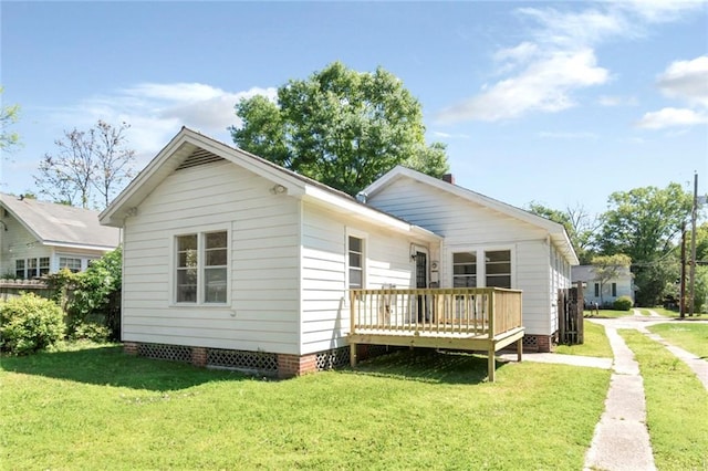 back of property with a lawn and a wooden deck