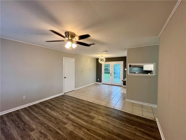 8636 Boe Rd, Irvington, AL 36544 - spare room featuring wood finished floors, french doors, ceiling fan, crown molding, and a chandelier