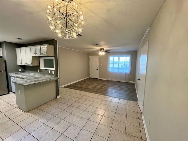 8636 Boe Rd, Irvington, AL 36544 - kitchen featuring freestanding refrigerator, white cabinetry, light tile patterned floors, baseboards, and a chandelier