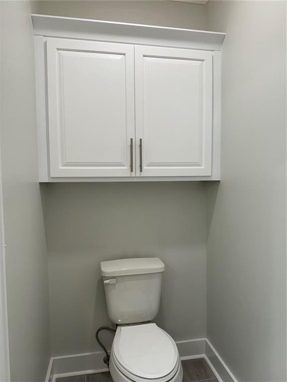 bathroom with toilet and tile floors