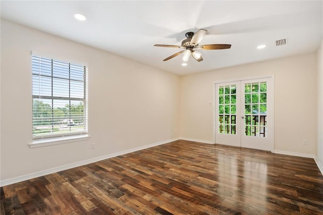 spare room with dark hardwood / wood-style flooring, ceiling fan, french doors, and a healthy amount of sunlight