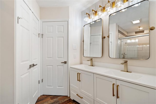 bathroom with a shower with door, vanity, and hardwood / wood-style floors