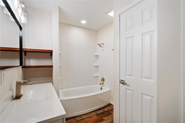 bathroom featuring hardwood / wood-style flooring, washtub / shower combination, and vanity