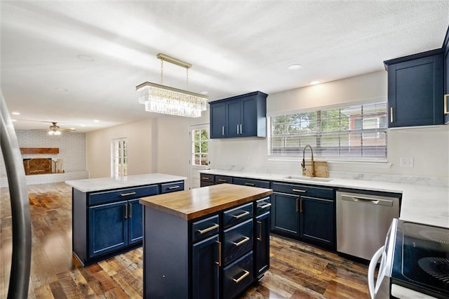 kitchen featuring butcher block countertops, stainless steel dishwasher, a center island, and blue cabinetry