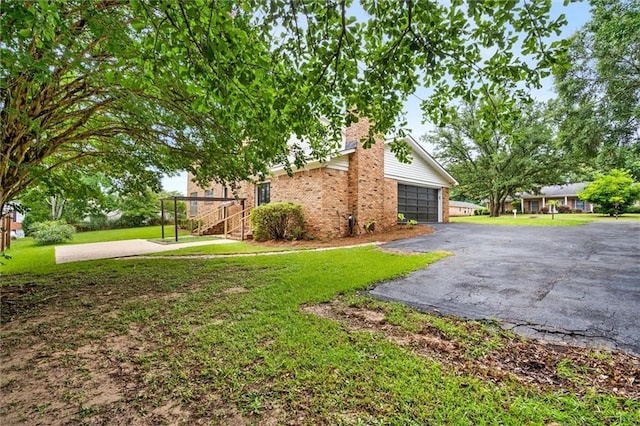 view of side of property with a garage and a lawn