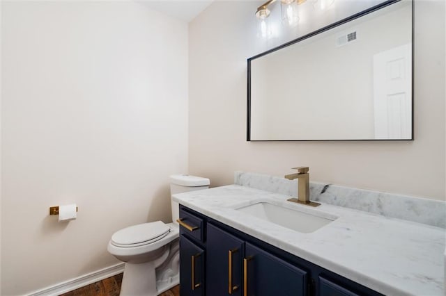 bathroom featuring vanity, wood-type flooring, and toilet