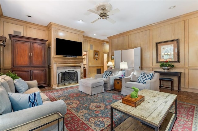 living room featuring a fireplace, wood-type flooring, and ceiling fan