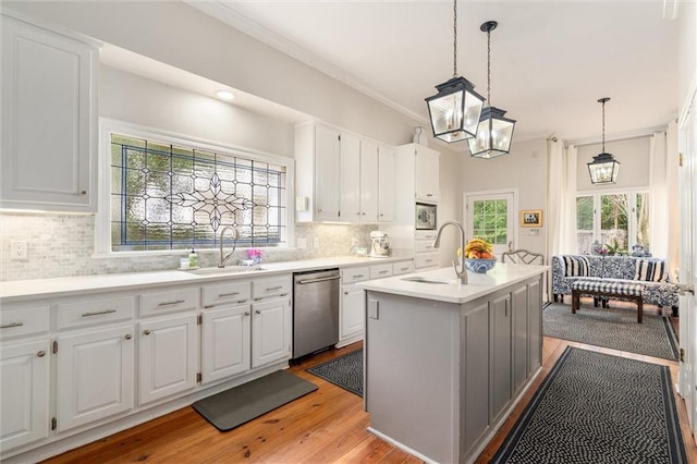 kitchen with stainless steel appliances, backsplash, sink, and a center island with sink