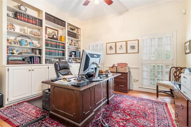 office area featuring crown molding, built in shelves, ceiling fan, and wood-type flooring