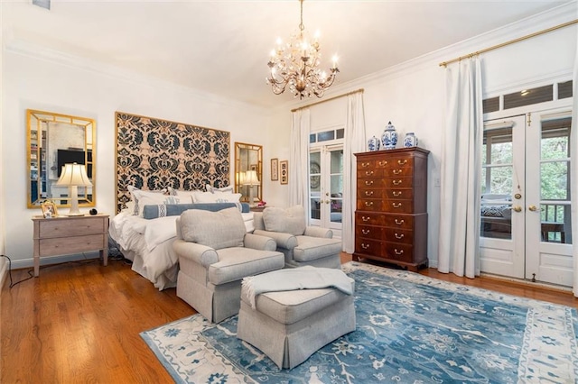 bedroom with wood-type flooring, french doors, access to exterior, and a chandelier