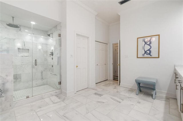 bathroom featuring a shower with door, vanity, crown molding, and tile patterned floors