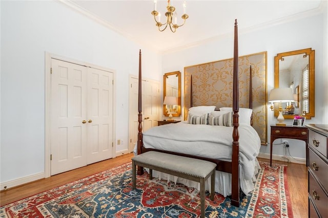 bedroom featuring light hardwood / wood-style floors, a notable chandelier, and ornamental molding