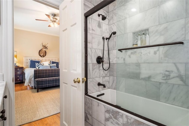 bathroom featuring ceiling fan, wood-type flooring, combined bath / shower with glass door, and ornamental molding