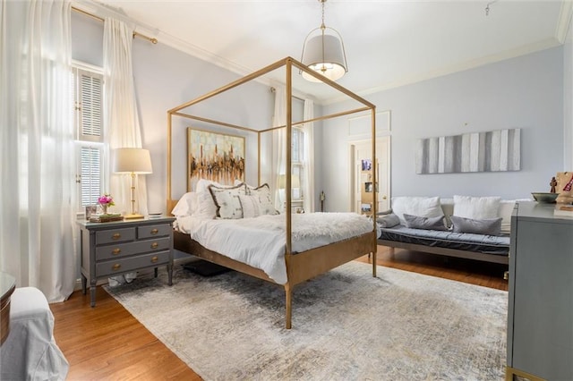 bedroom with ornamental molding and wood-type flooring