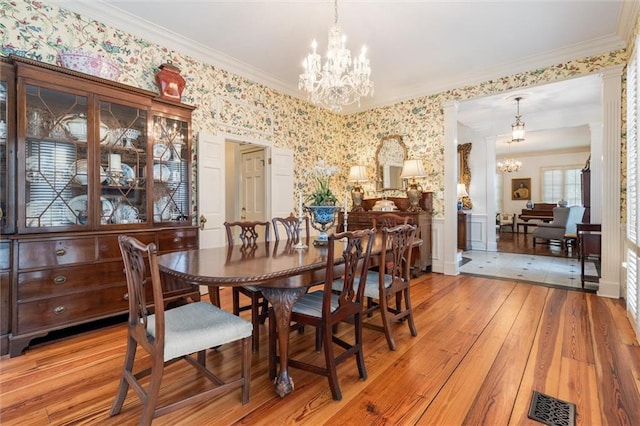 dining room with light hardwood / wood-style flooring, a chandelier, and ornamental molding