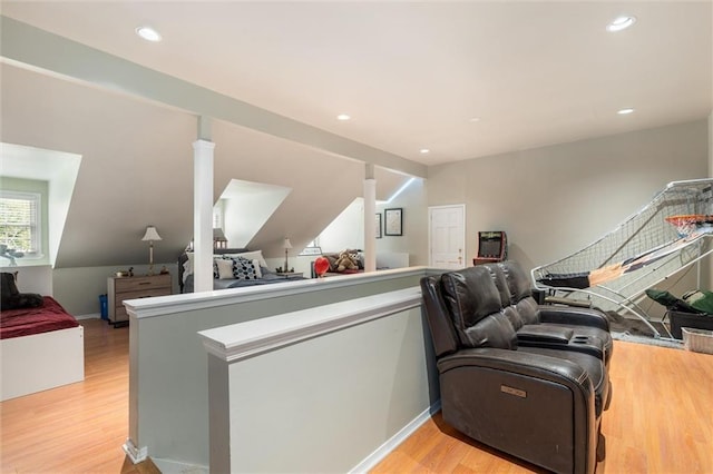 office area with light hardwood / wood-style flooring, decorative columns, and lofted ceiling