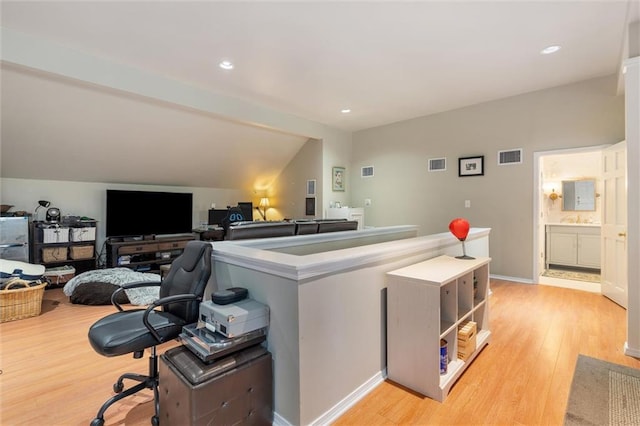 office area with vaulted ceiling and light hardwood / wood-style flooring