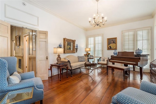 sitting room with crown molding, a chandelier, and wood-type flooring