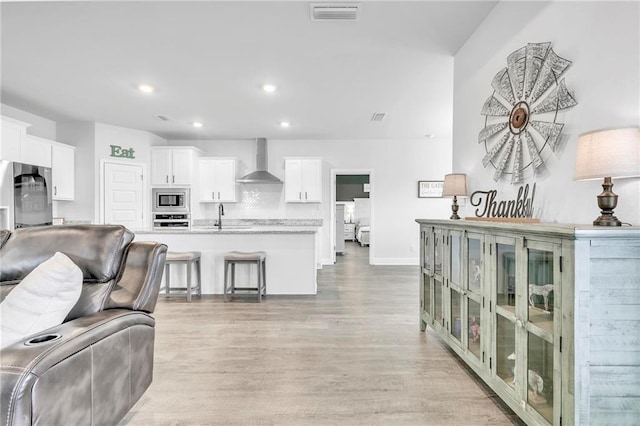 living room featuring light wood-style flooring, recessed lighting, and baseboards