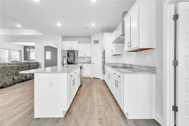 kitchen with a sink, appliances with stainless steel finishes, light wood-type flooring, white cabinetry, and recessed lighting