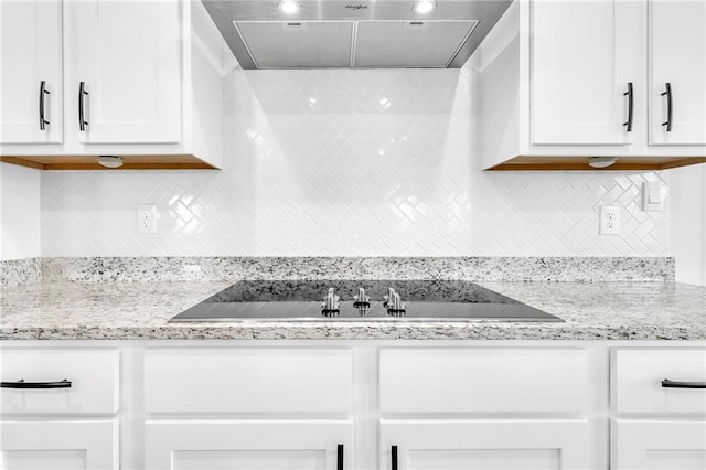 kitchen with ventilation hood, white cabinetry, black electric cooktop, tasteful backsplash, and light stone countertops