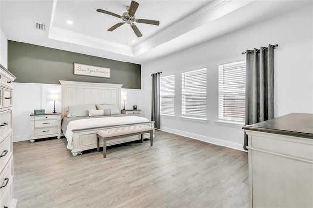 bedroom featuring a raised ceiling, crown molding, light wood-style floors, recessed lighting, and a ceiling fan
