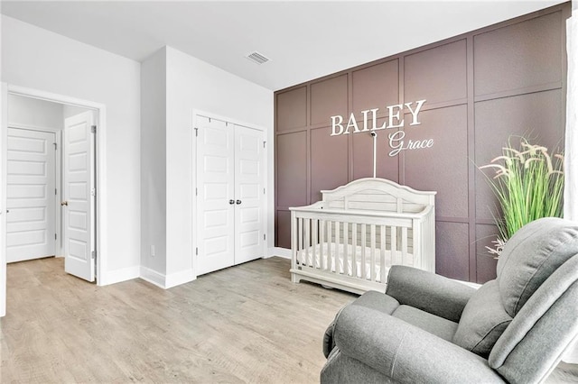 bedroom with light wood-style flooring, a closet, and baseboards