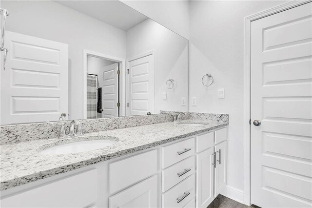 bathroom with double vanity and curtained shower