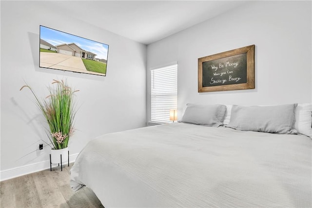 bedroom featuring wood finished floors and baseboards